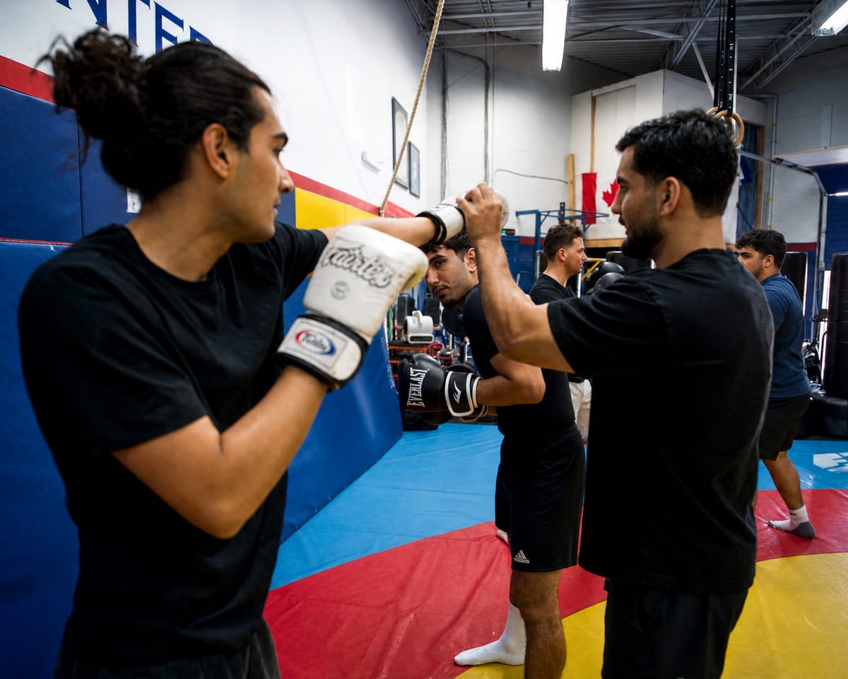 Coach holding focus mitts for a student during pad work