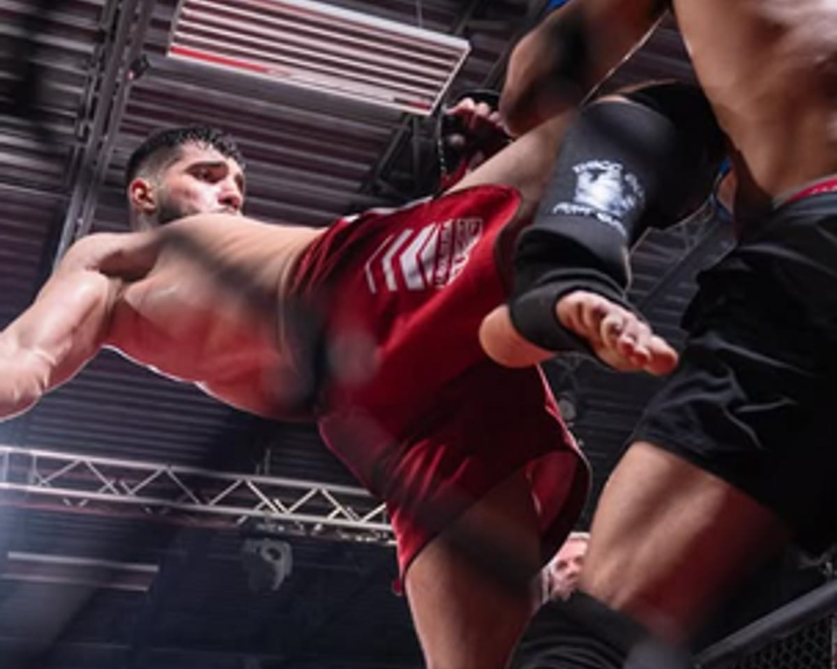 Fighter throwing a flying knee in an MMA cage match